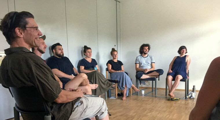 Menschen sitzen im Kreis